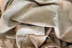 Fitted mattress protector gathered in soft folds, included with the Nurture